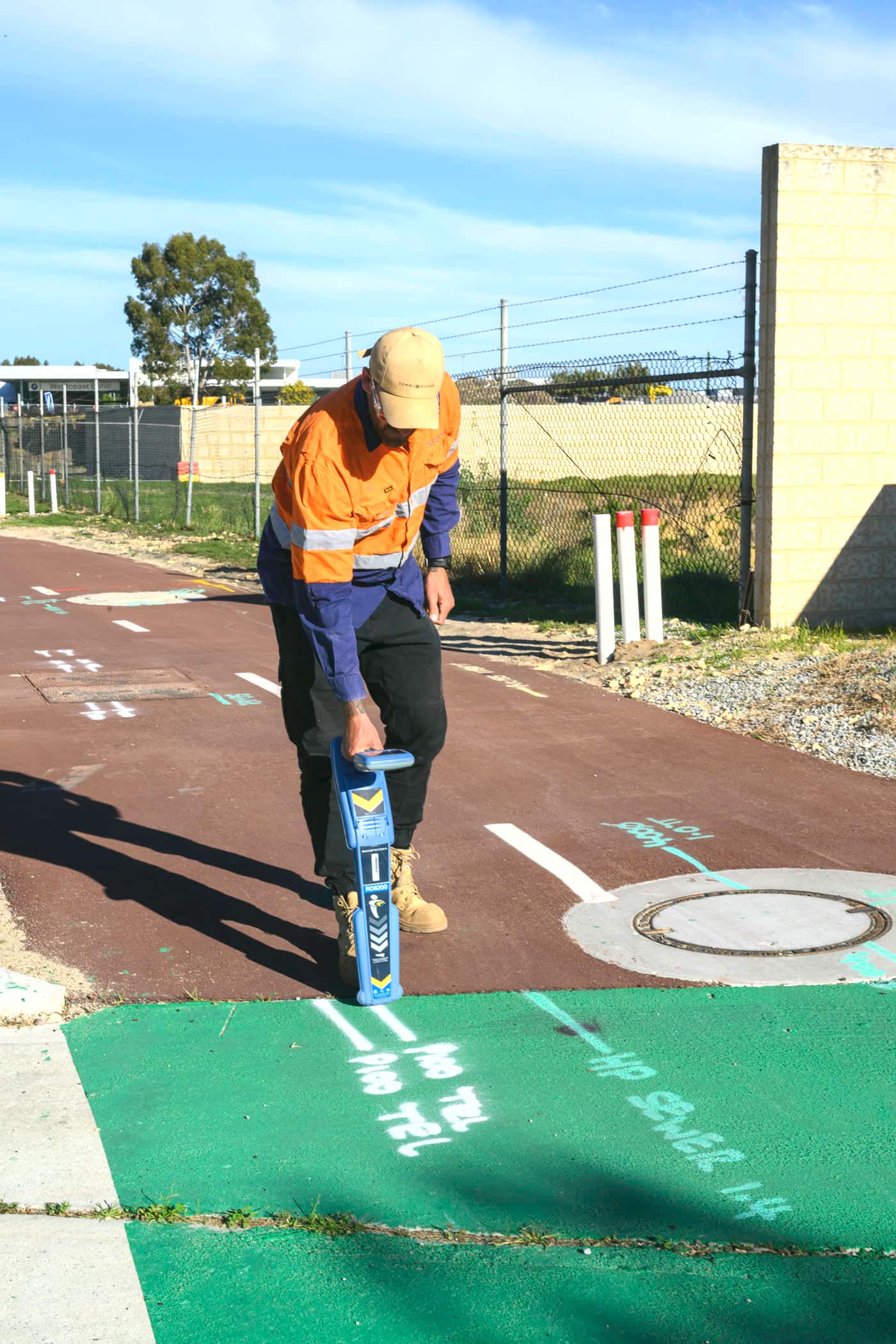A Scope Mapping locator tracing an underground service with an electromagnetic locating wand over marked ground