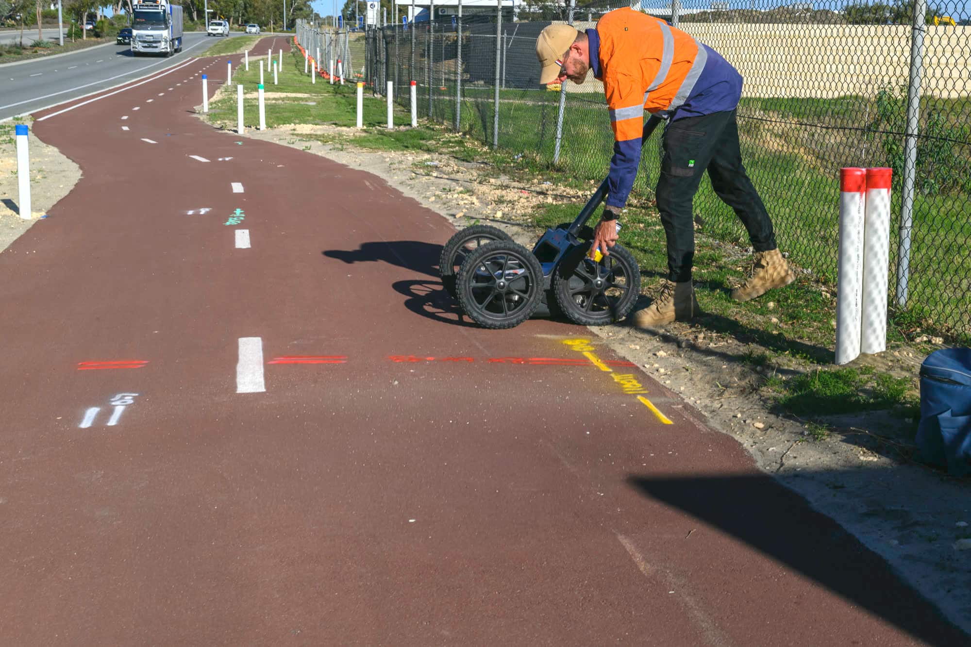 A Scope Mapping locator running a ground penetrating radar cart along a shared path beside marked services