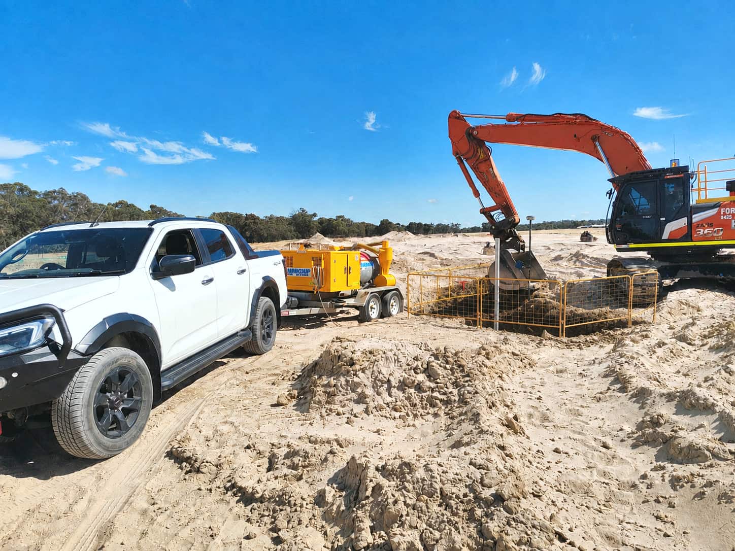 A Scope Mapping vehicle and vacuum excavation trailer on a Western Australian sand site, with an excavator and barricaded excavation behind